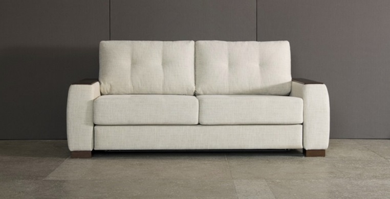 Белый диван на фоне серых стен 